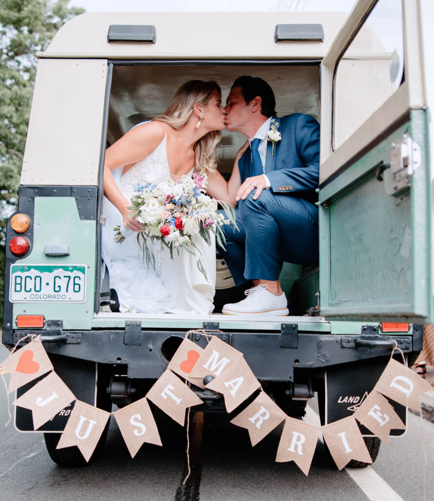 Newlywed couple sharing a passionate kiss in a vintage car after their ceremony, captured by the best NYC based wedding photographer, David Alan Visuals.
