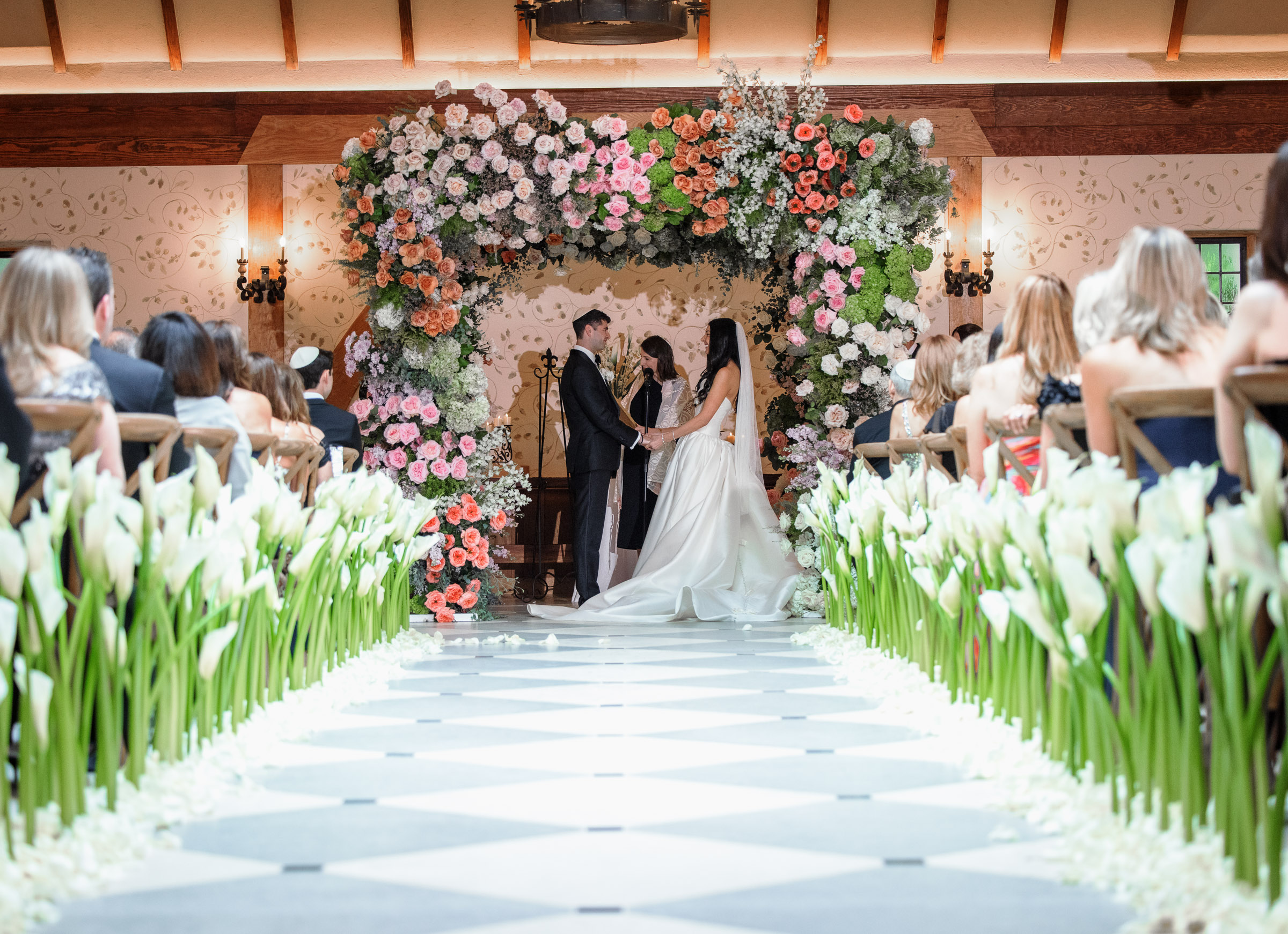Wide view of Casey and Jacob beneath their floral chuppah