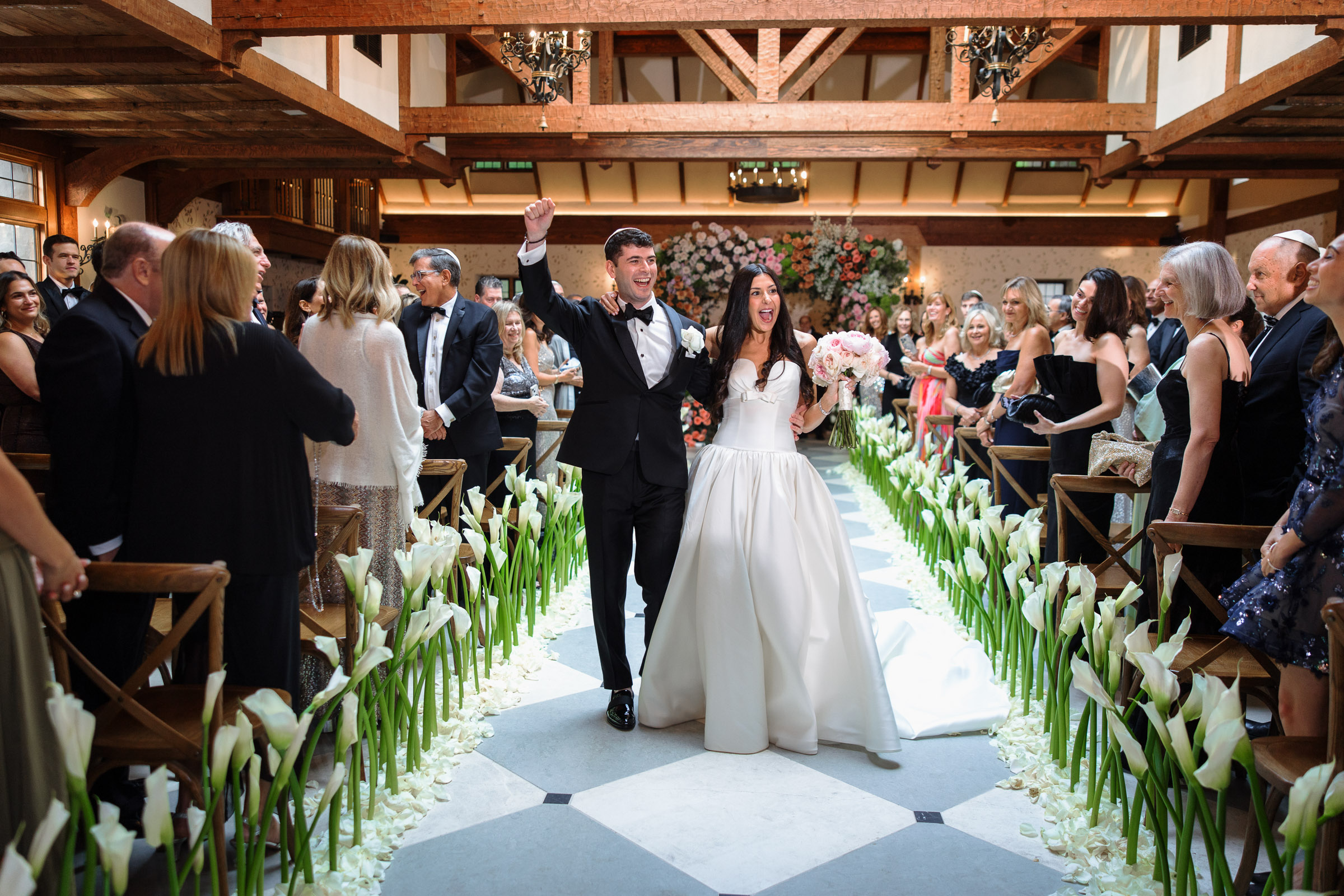 Casey and Jacob smiling as they walk back through the ceremony aisle