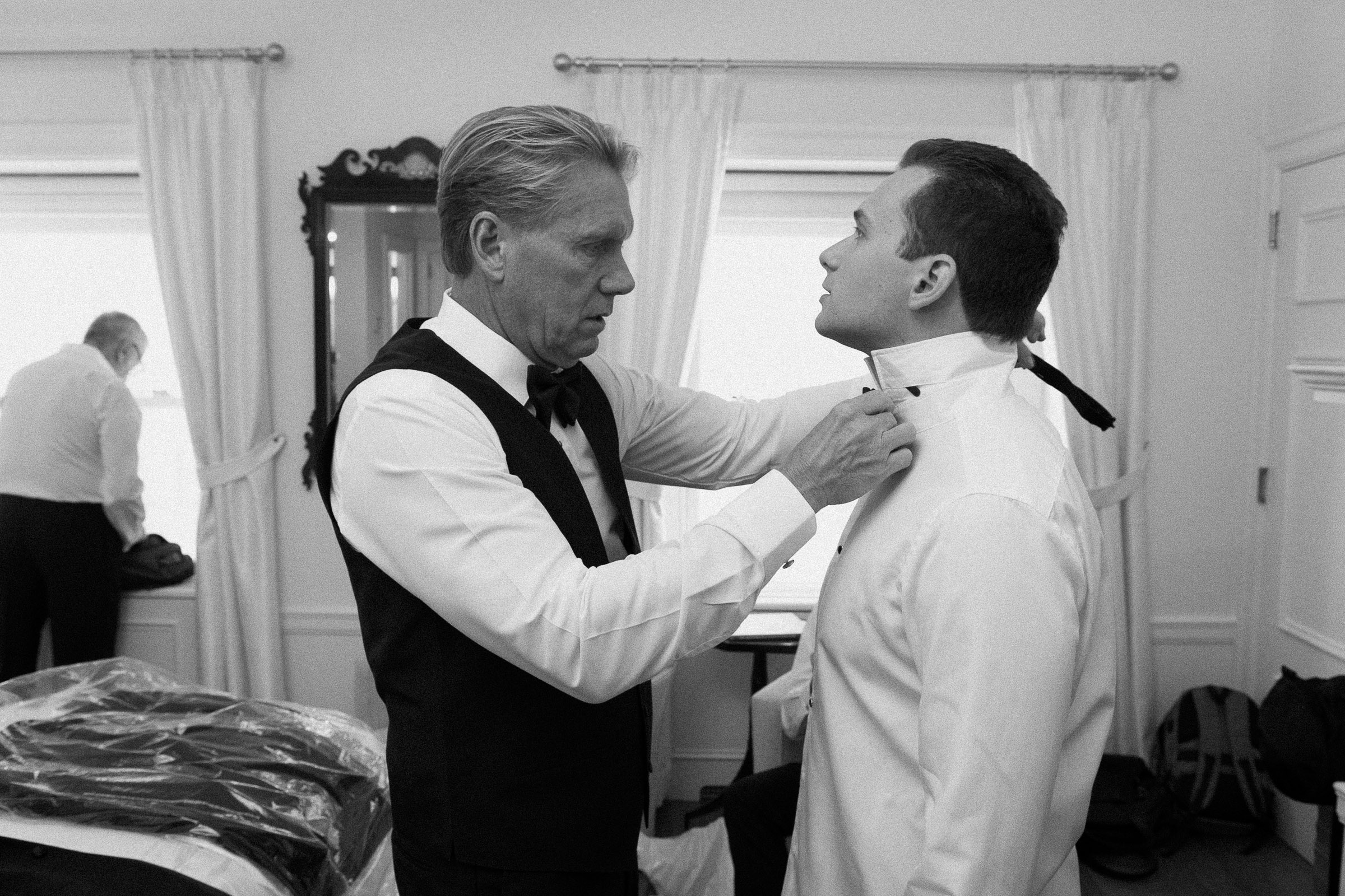 Cameron's father helping him adjust his bow tie