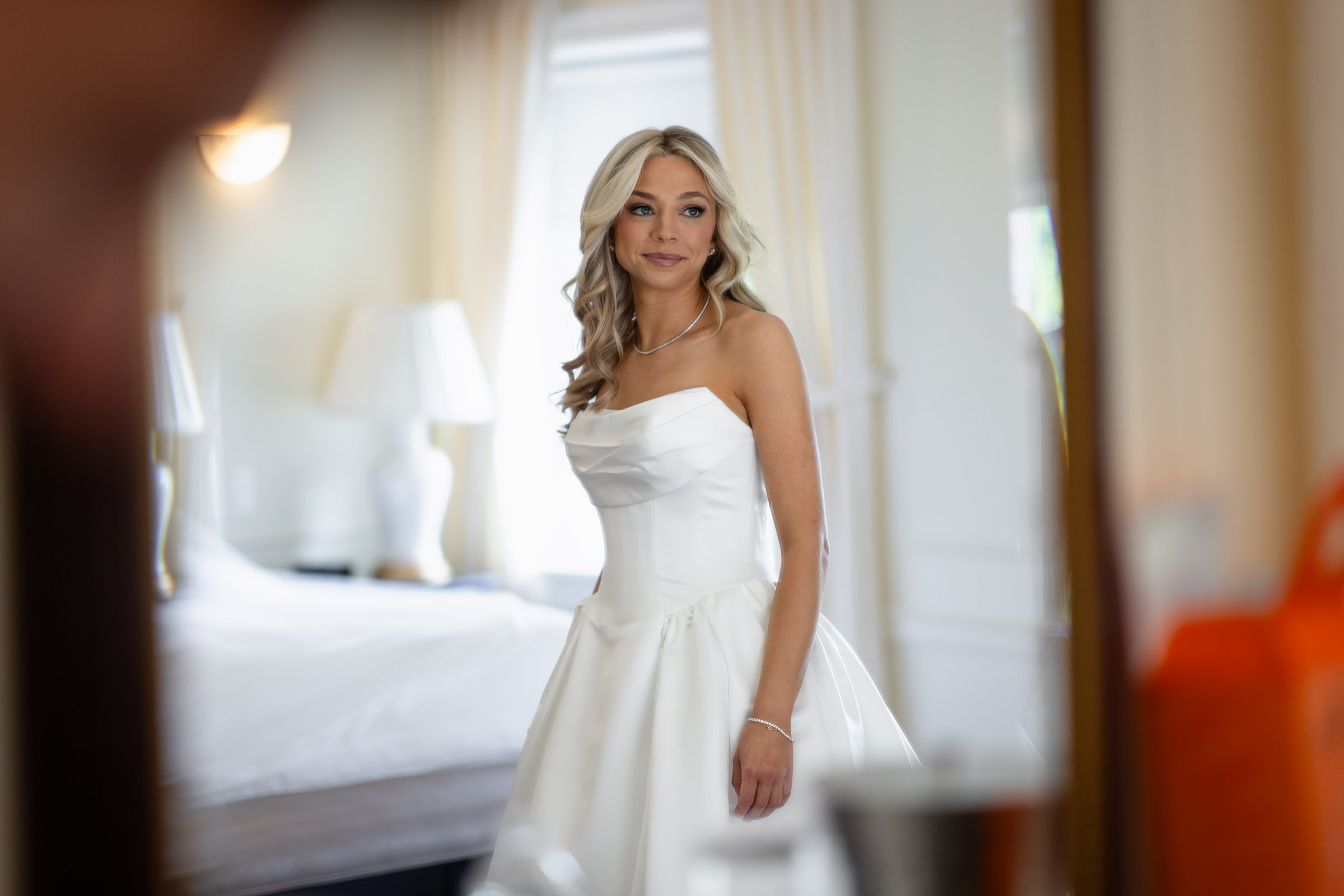 Colette in her wedding dress photographed through a doorway