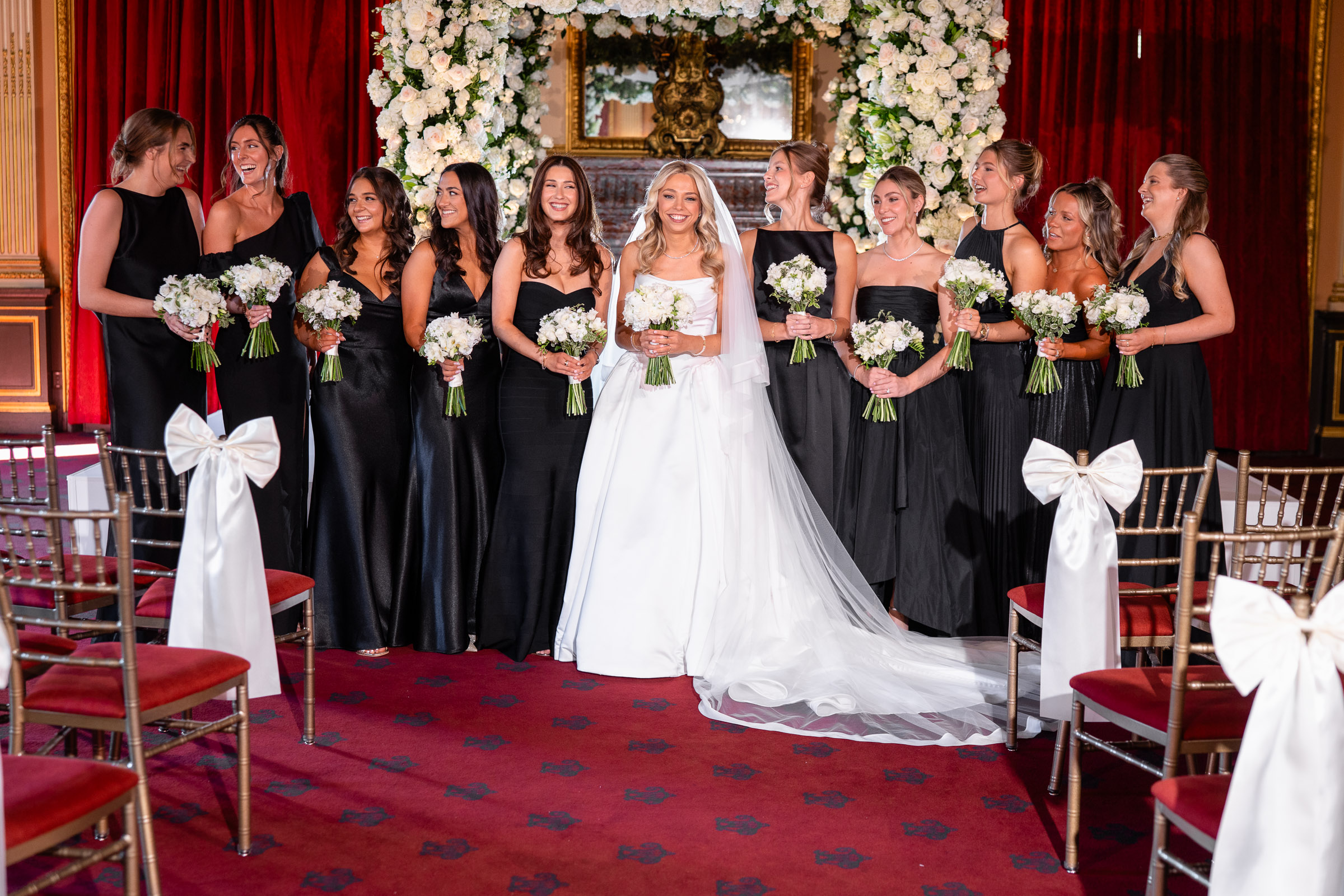 Wedding party portrait in front of a white floral chuppah