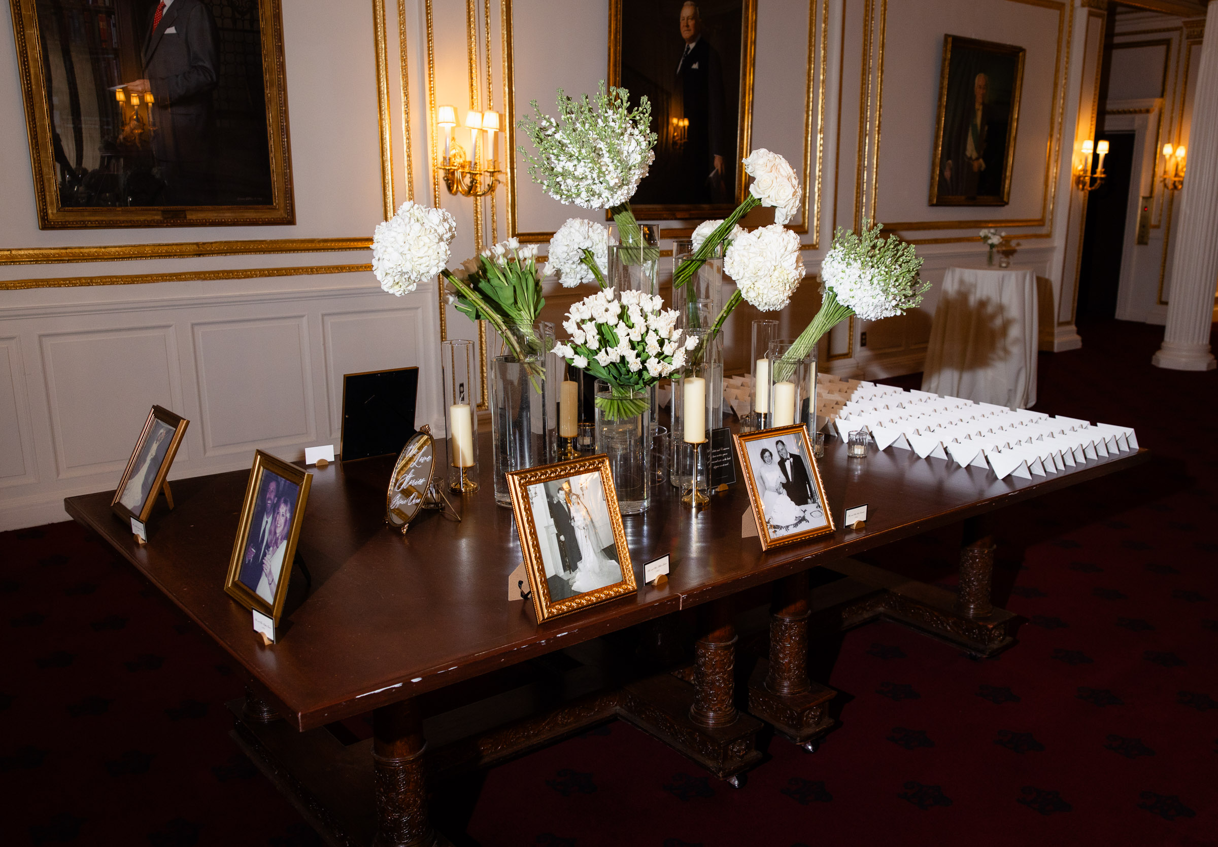 Framed family photographs and white flowers on a memorial table