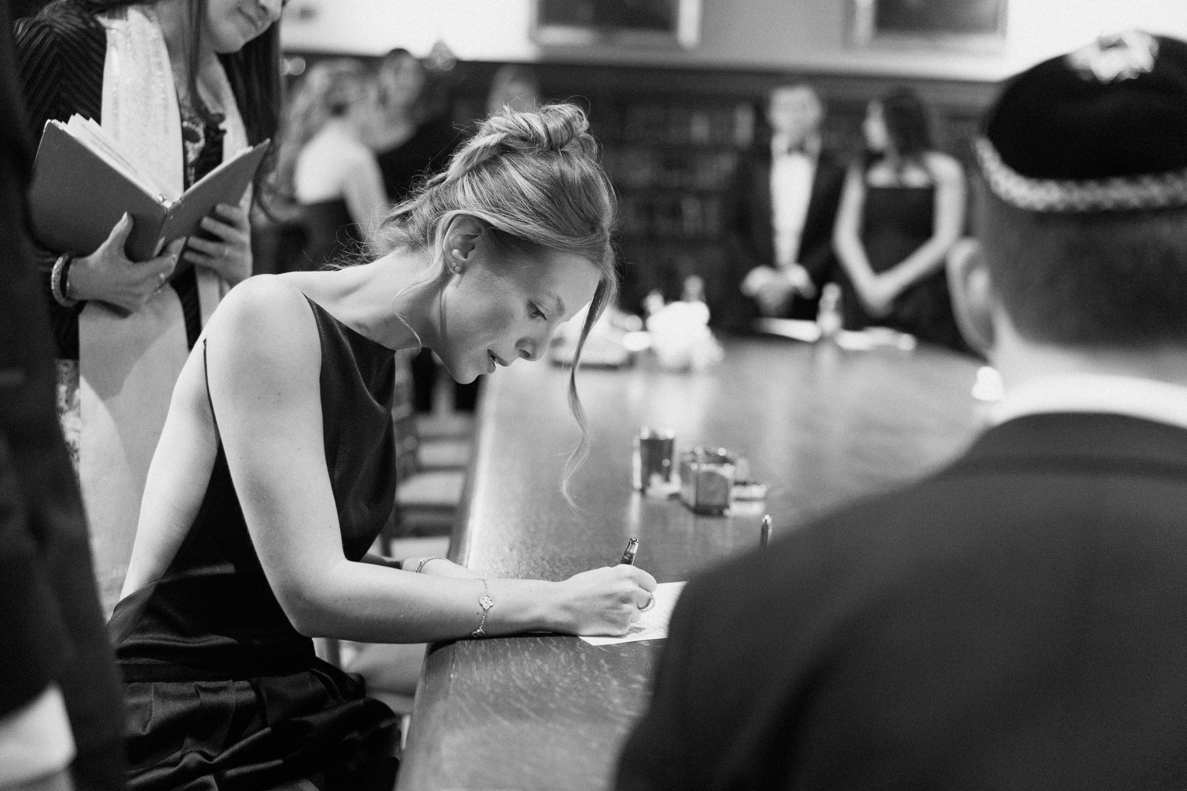 Black-and-white photograph of Colette signing the ketubah