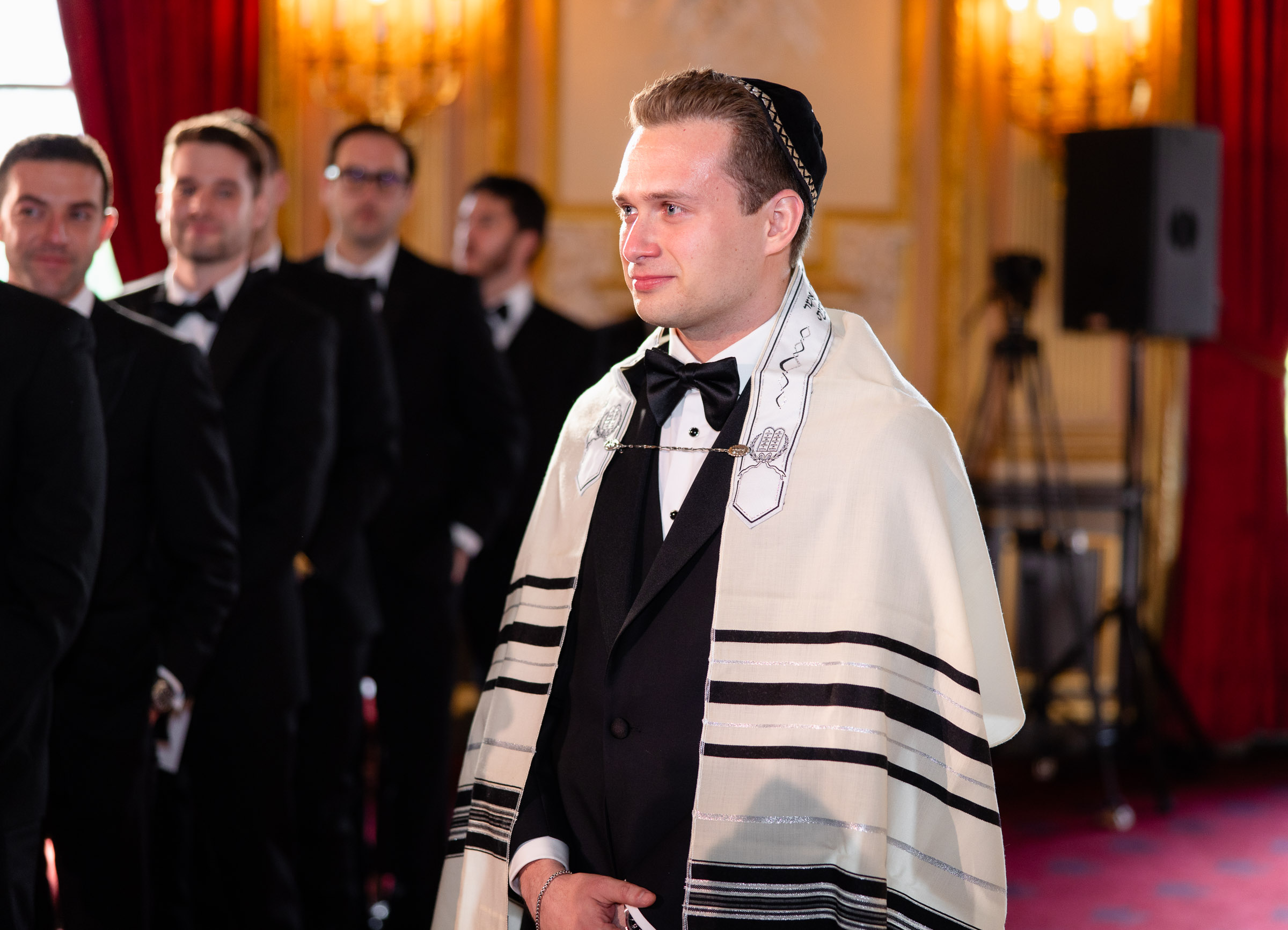 Cameron waiting beneath the chuppah wearing a tallit