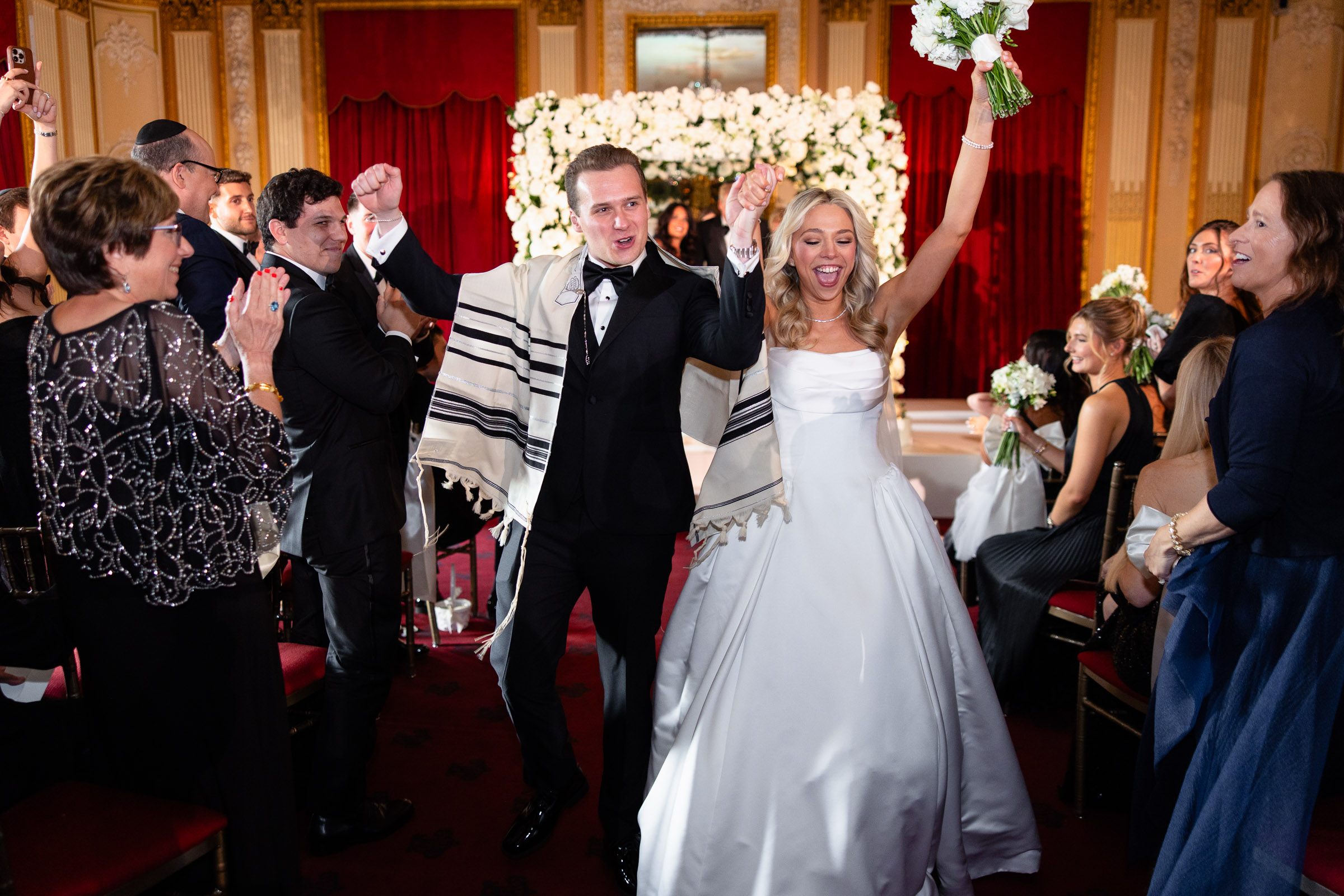 Colette and Cameron celebrating as they walk back up the aisle