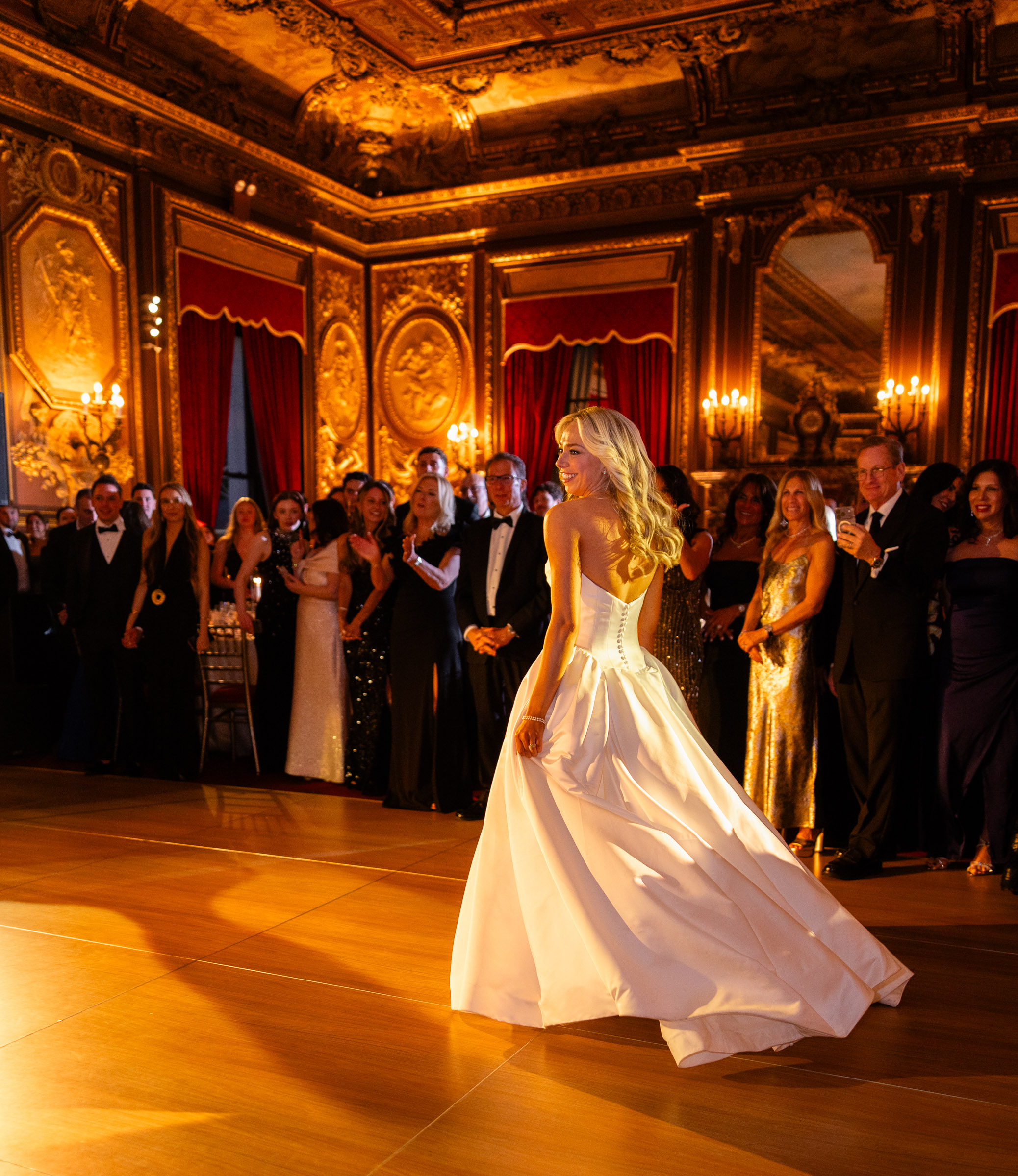 Colette's wedding dress moving through warm light during the first dance