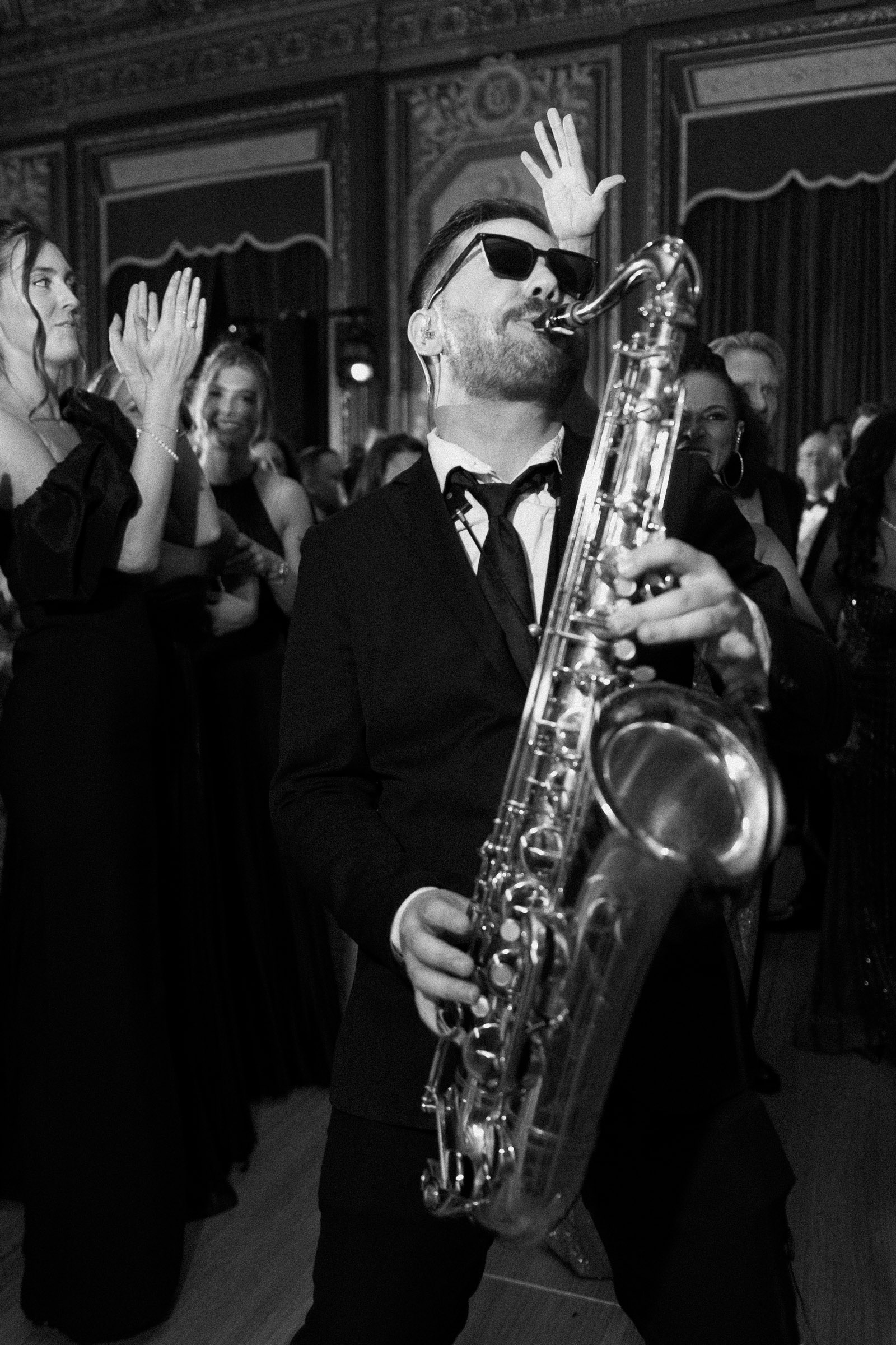 Saxophonist performing among wedding guests