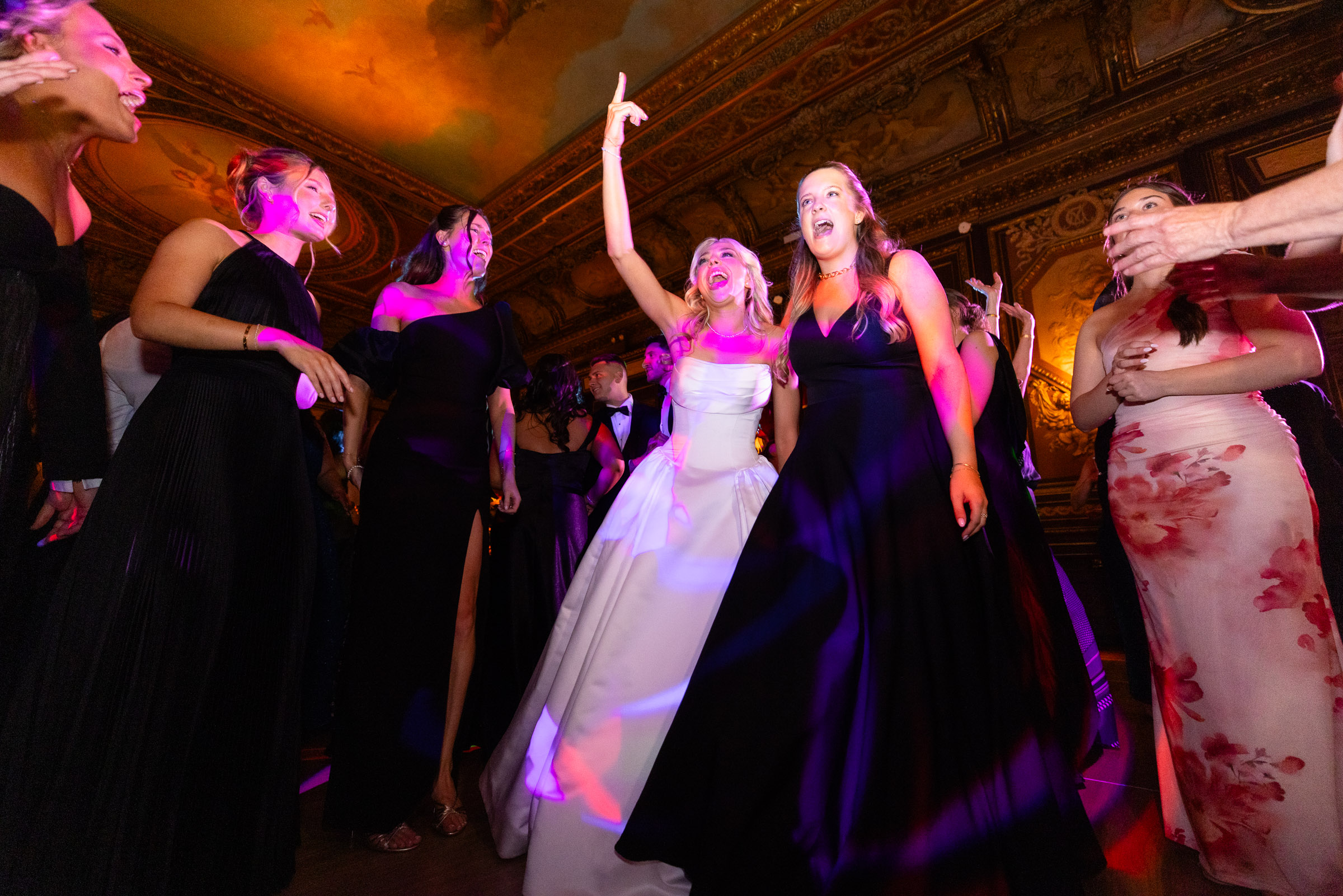 Colette dancing with friends under colorful reception lights