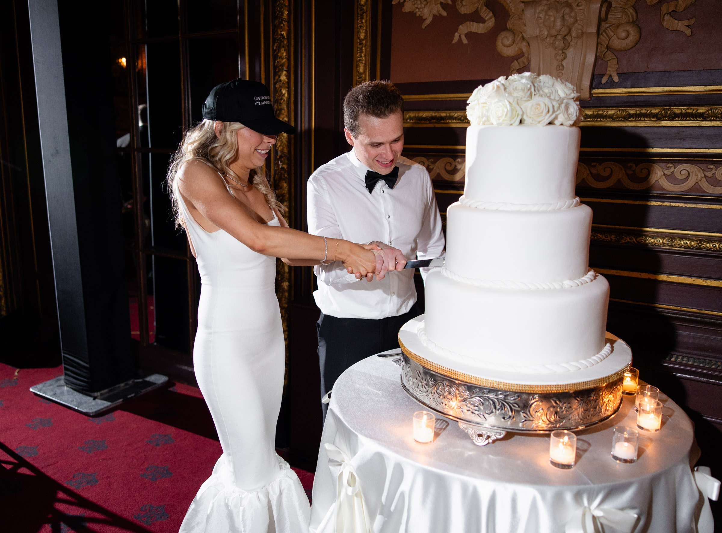 Colette and Cameron cutting their white wedding cake