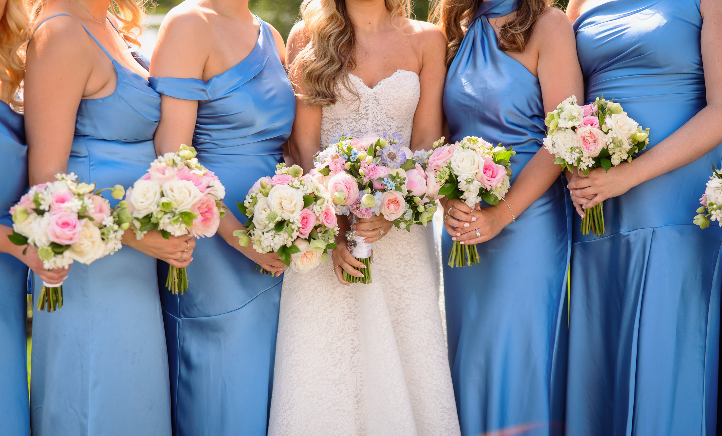 Bridesmaids holding pastel spring bouquets beside Liz