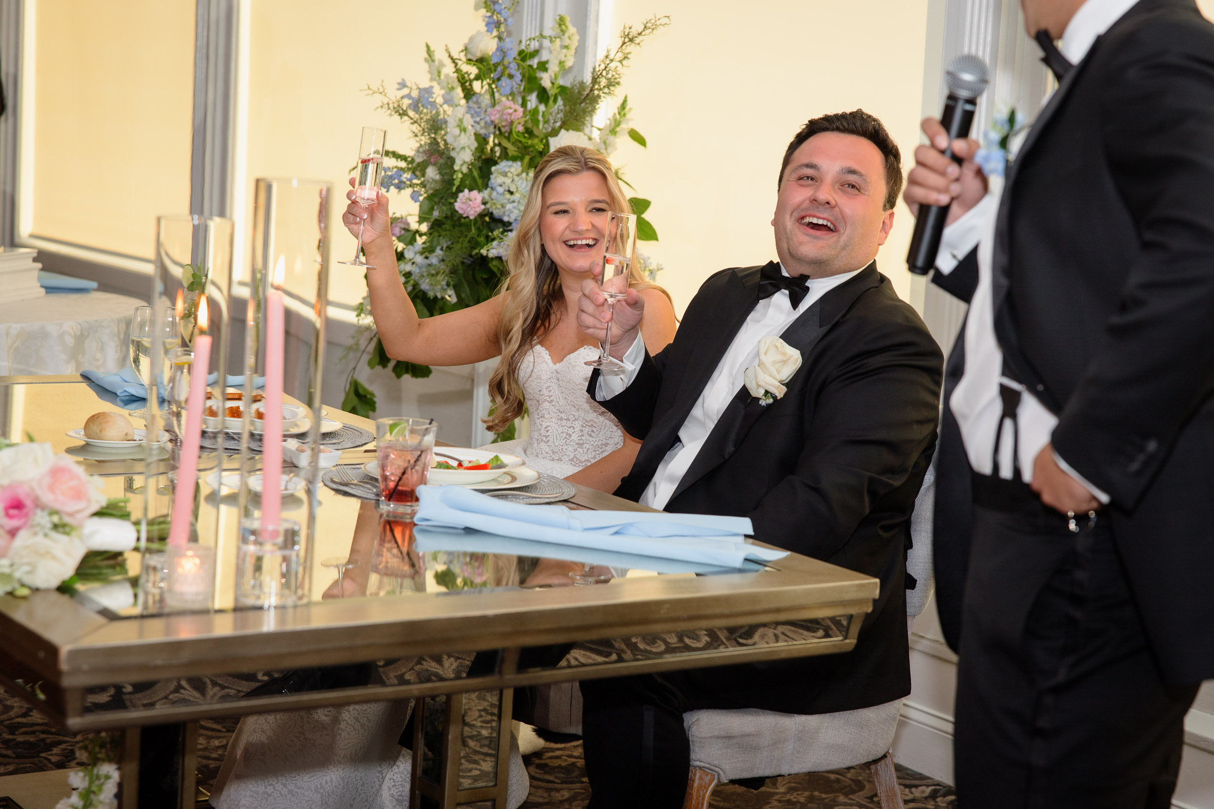 Liz and Austin laughing together during a wedding toast