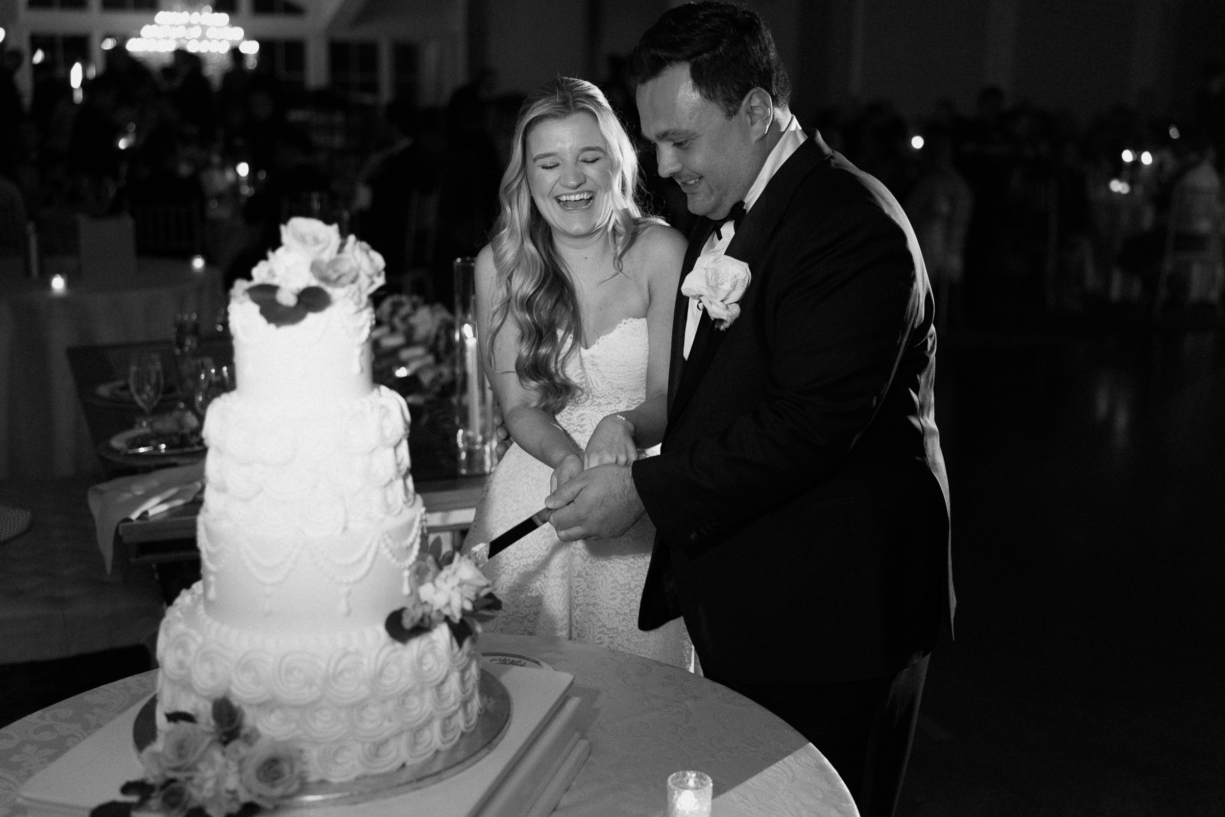 Black-and-white photograph of Liz and Austin cutting their wedding cake