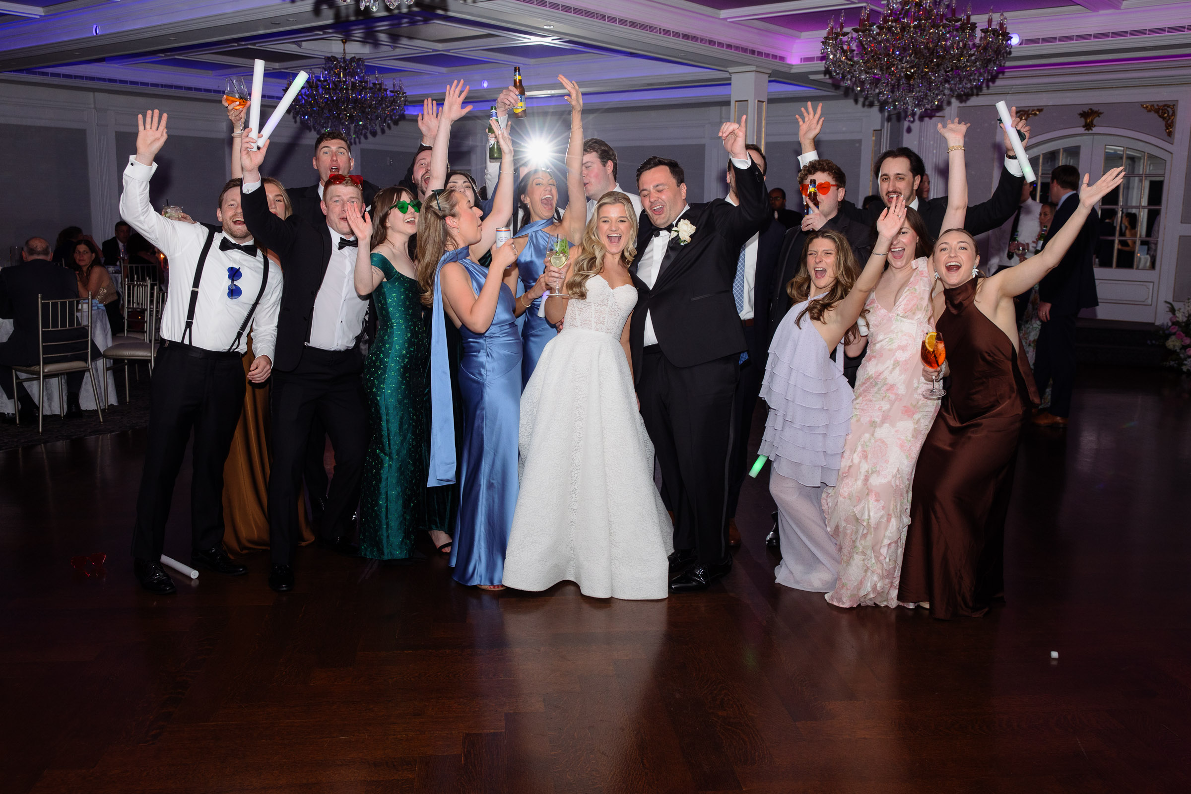 Wedding guests cheering around Liz and Austin at the end of the reception