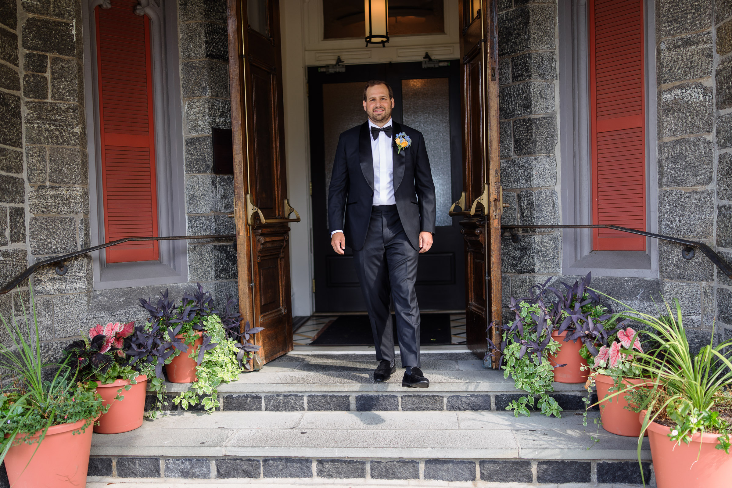 Ryan in a black tuxedo at Whitby Castle’s stone entrance