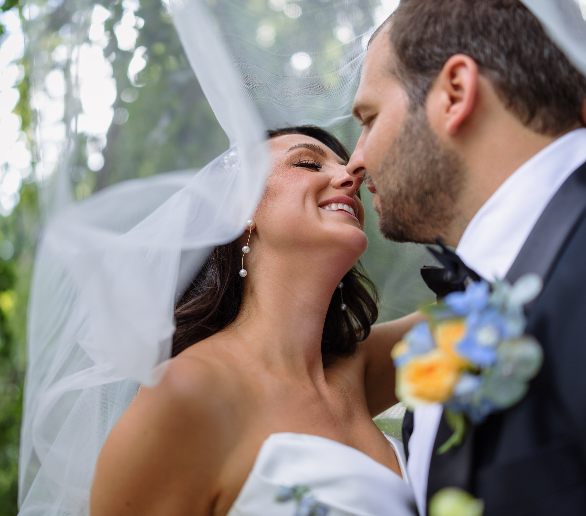 Intimate close-up of Alexandra and Ryan beneath her veil