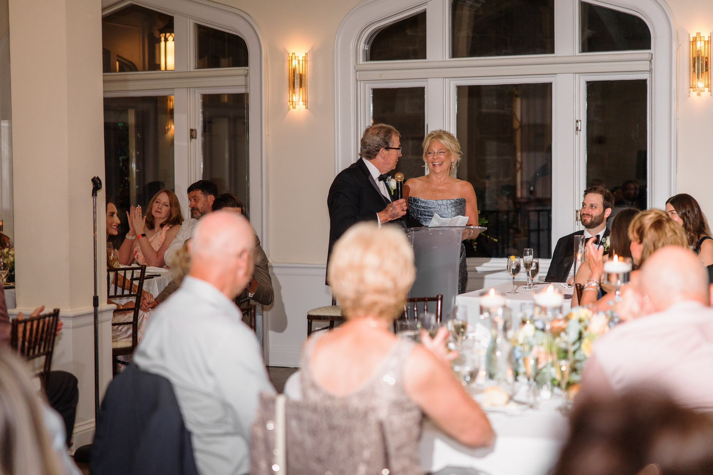 A reception toast drawing smiles from guests inside the ballroom