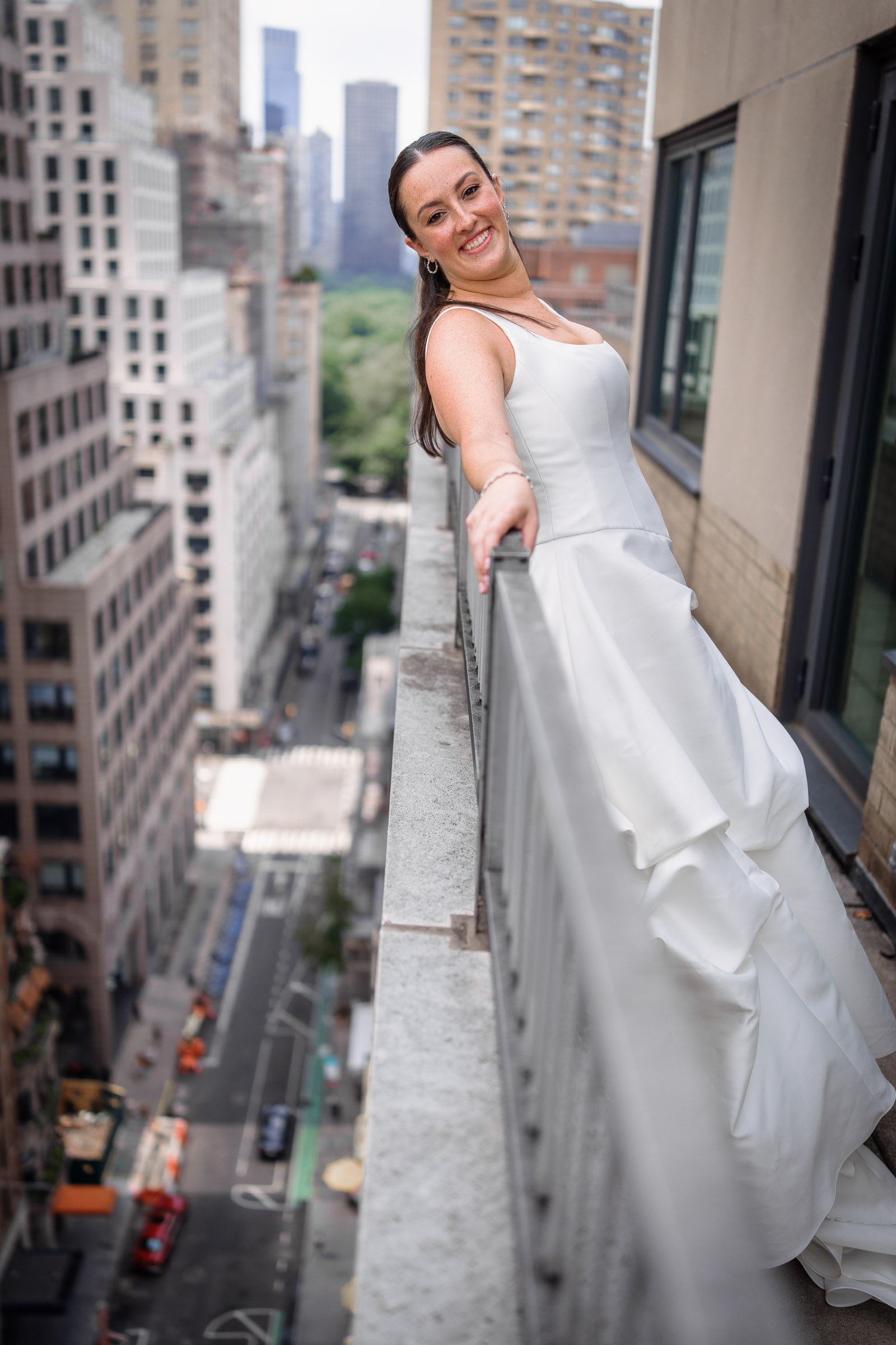 Bride in a sculptural wedding gown on a Manhattan hotel balcony above the city