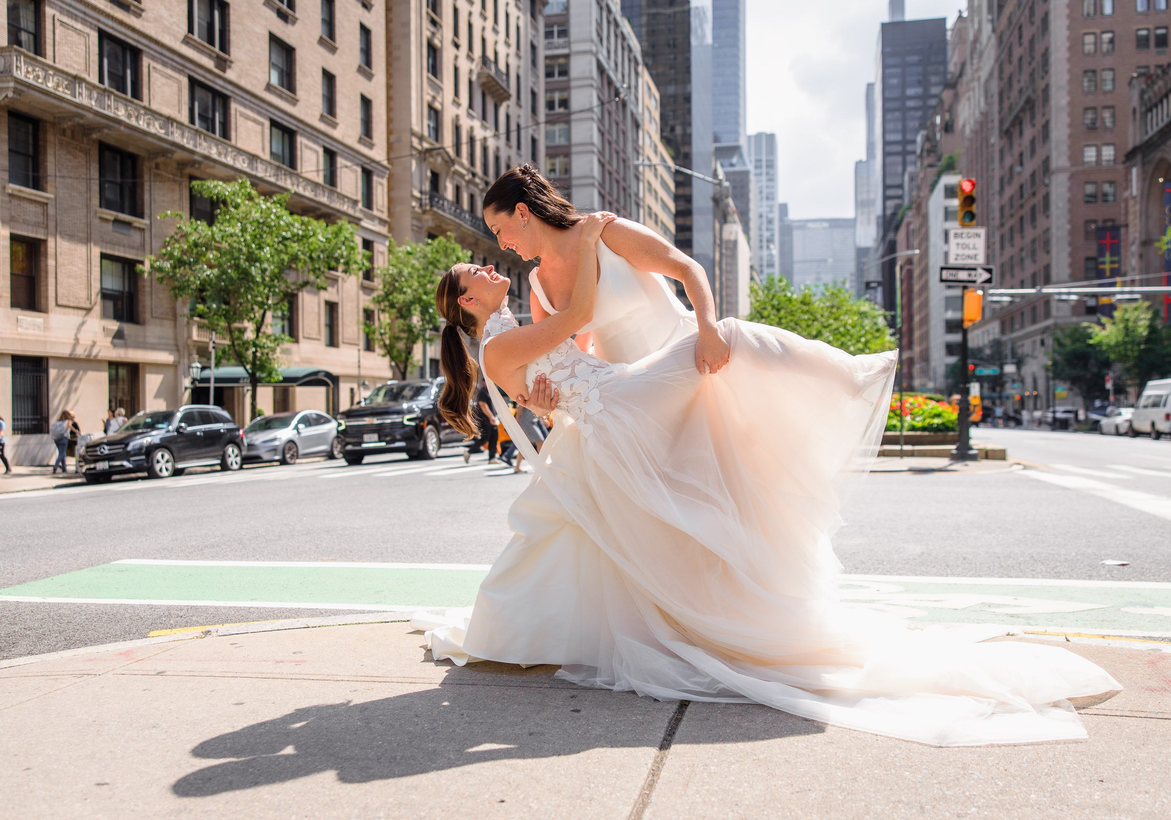Wide New York street portrait of Sydney and Delilah kissing beneath the skyline