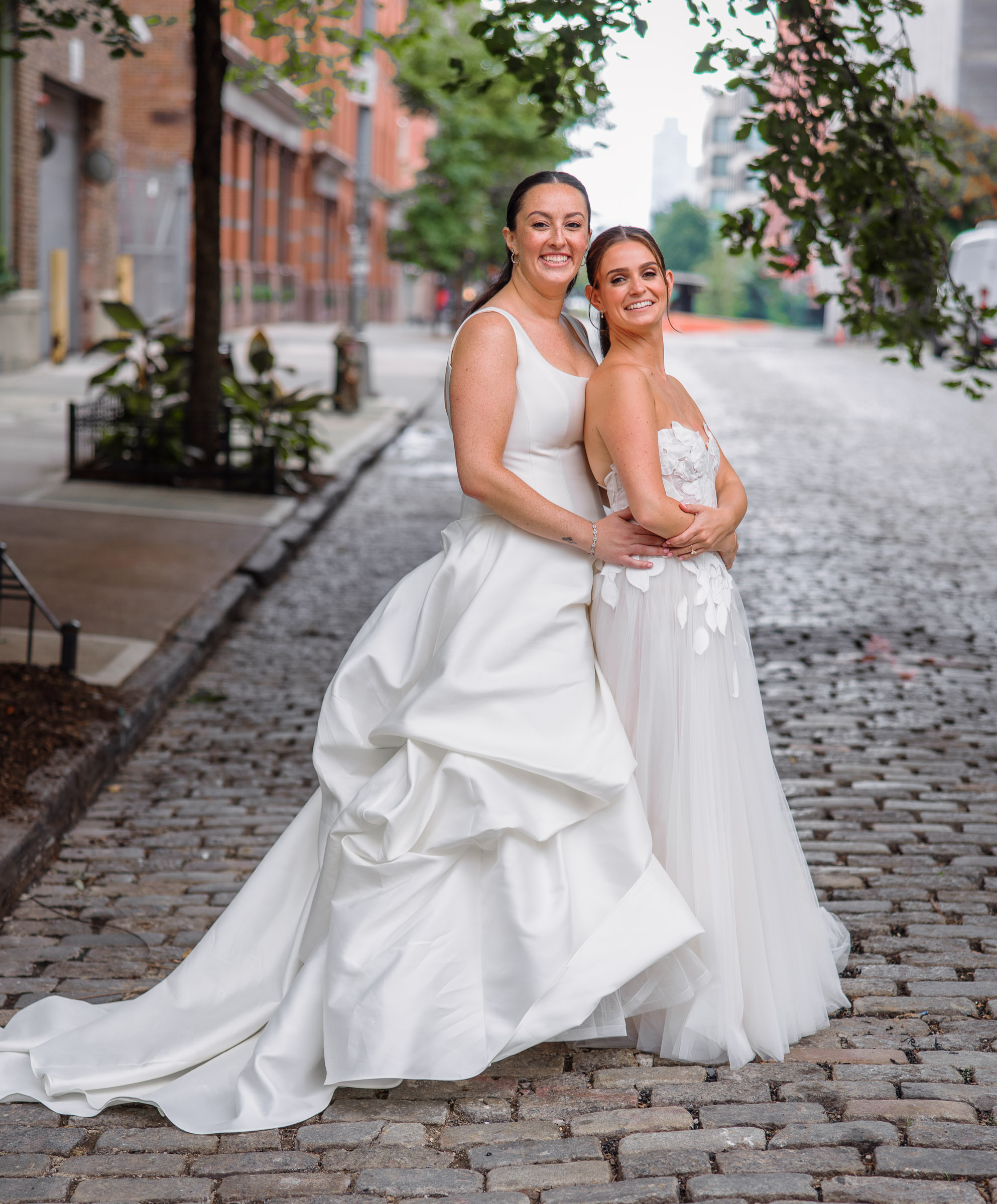 Sydney and Delilah walking hand in hand along a cobblestone street in Tribeca