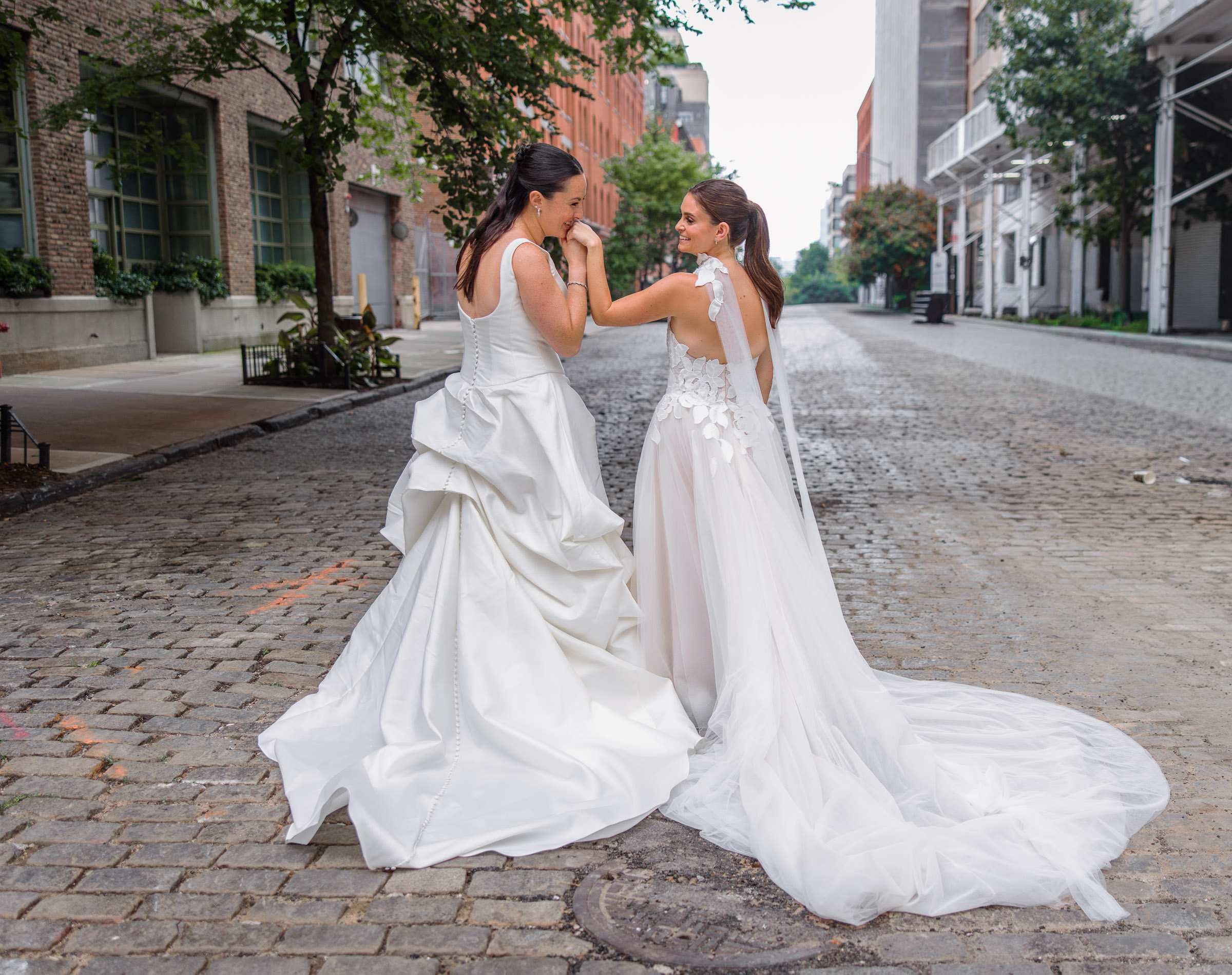 The brides dancing together on a quiet cobblestone block near Tribeca Rooftop