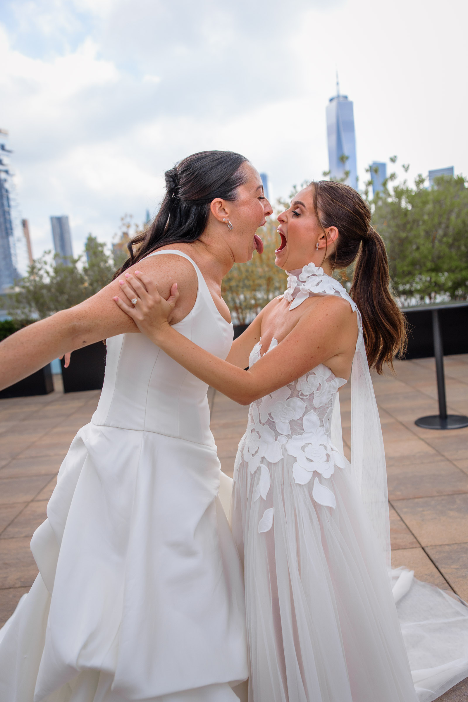 Sydney and Delilah sharing a kiss during their Tribeca Rooftop wedding with One World Trade Center behind them