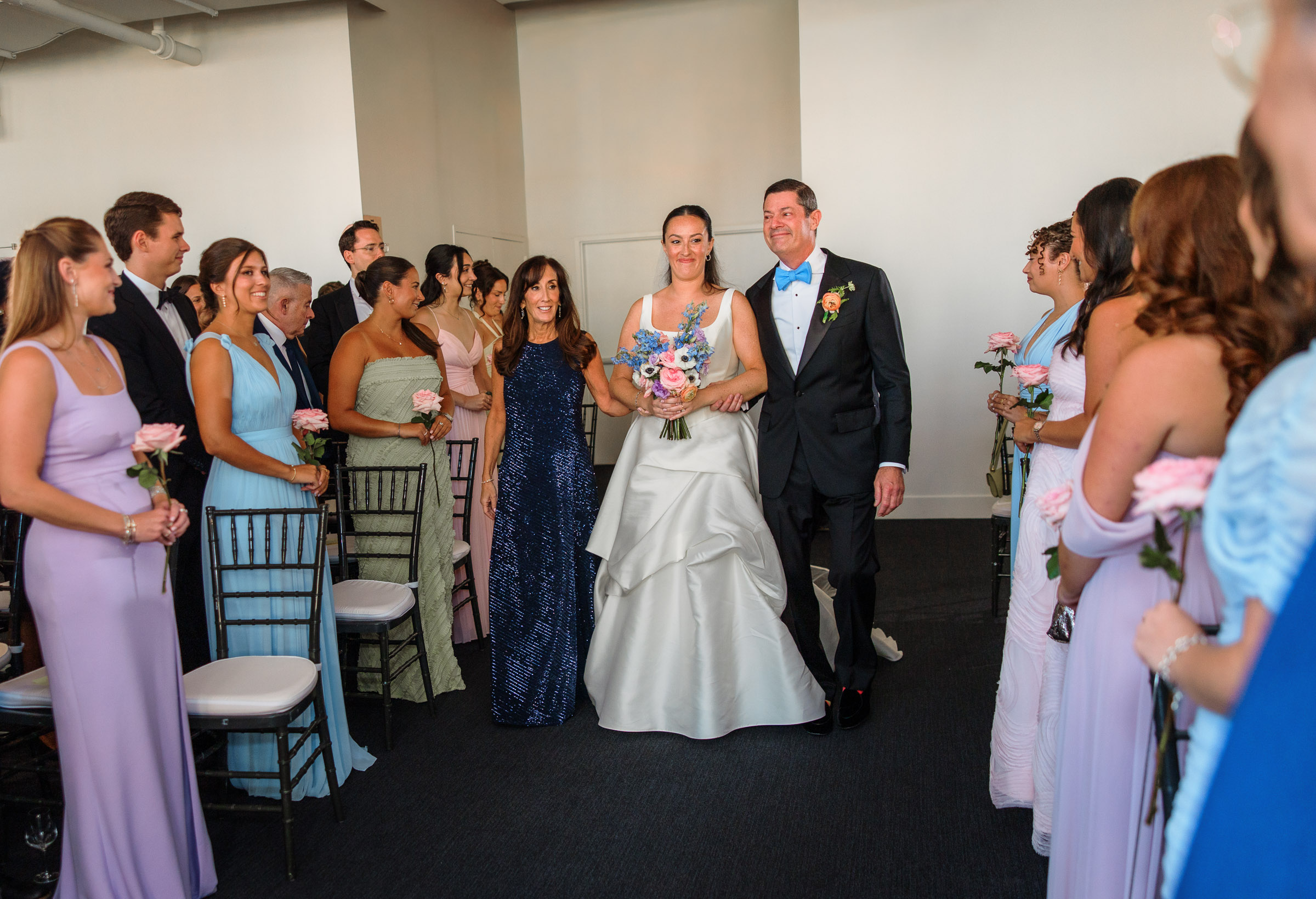 A wedding-party member walking down the aisle during the indoor Tribeca Rooftop ceremony