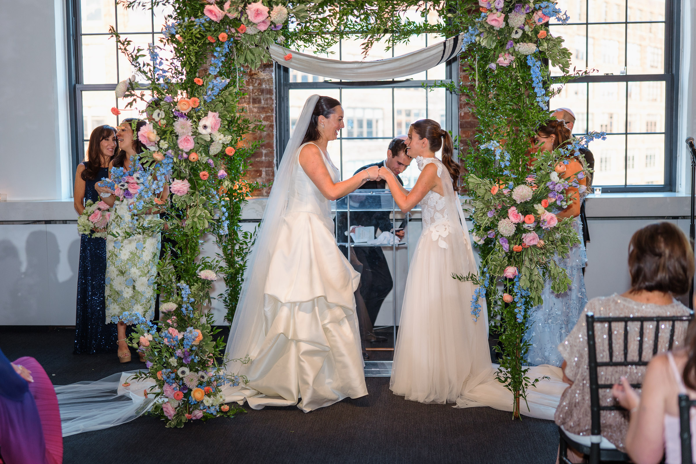 Sydney and Delilah holding hands during their indoor Tribeca Rooftop ceremony