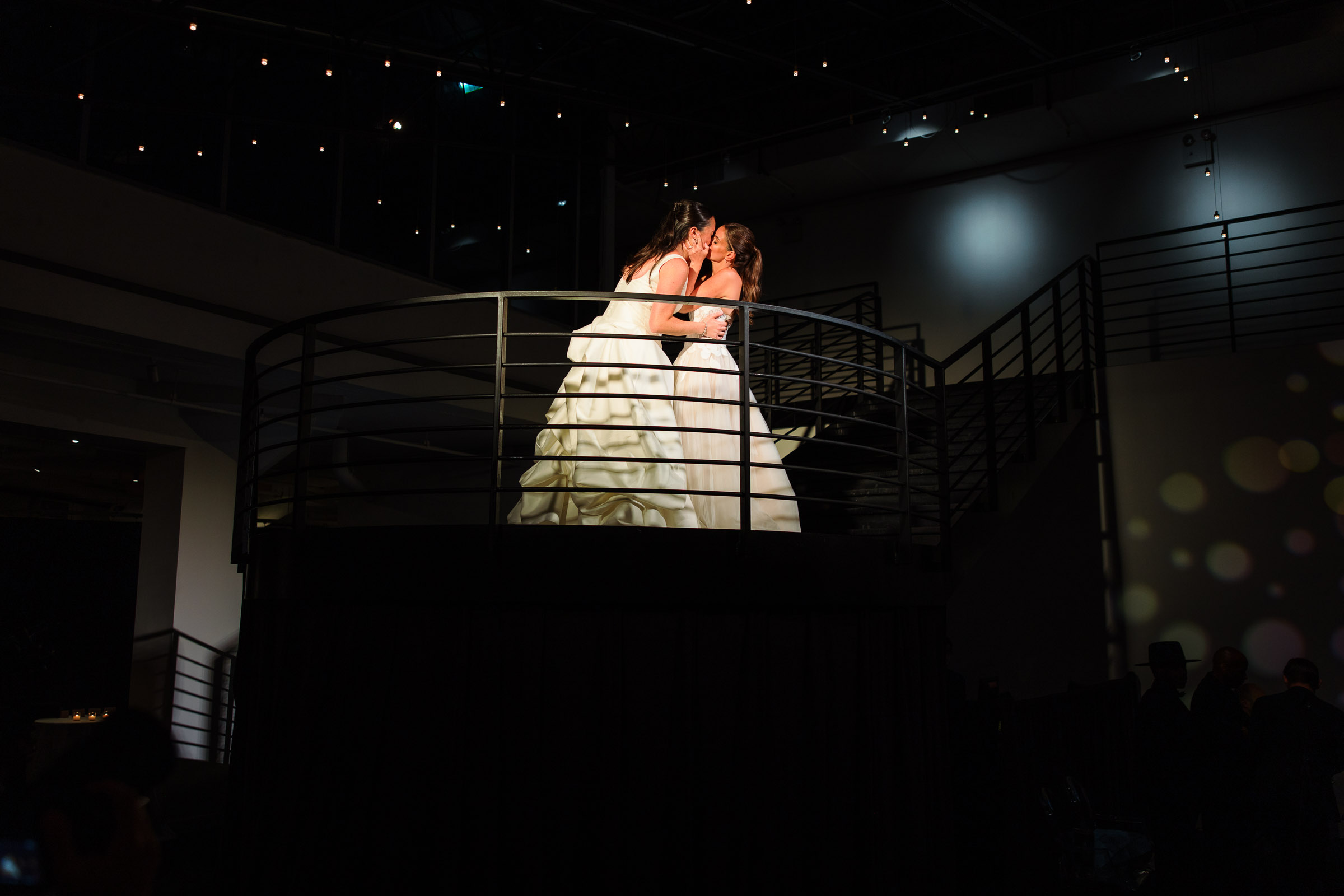 The newlyweds pausing above the dance floor before their reception entrance