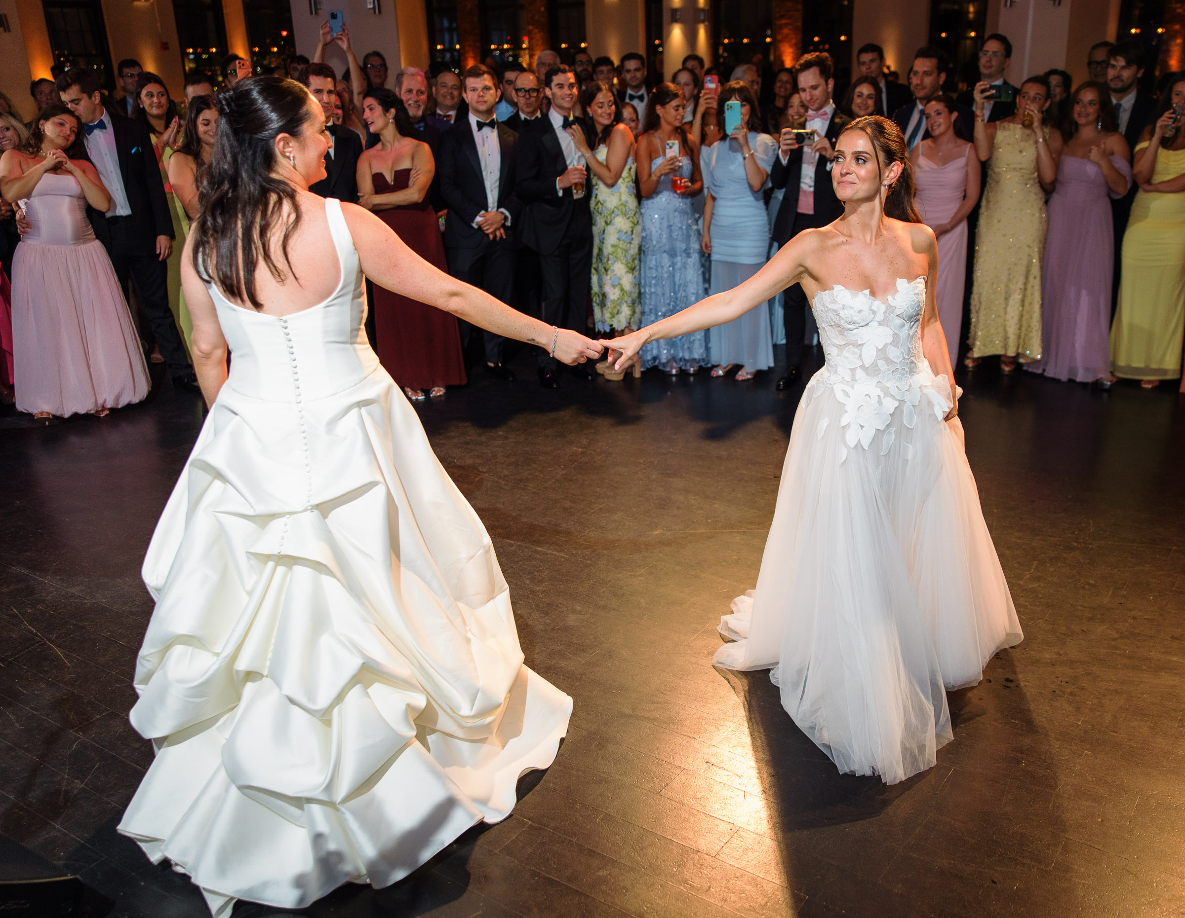 Sydney and Delilah dancing at the center of a circle of cheering guests