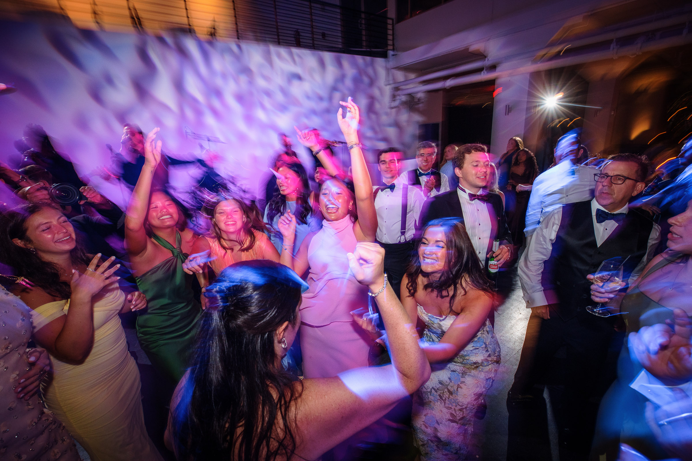 Guests dancing beneath purple reception lighting at Tribeca Rooftop